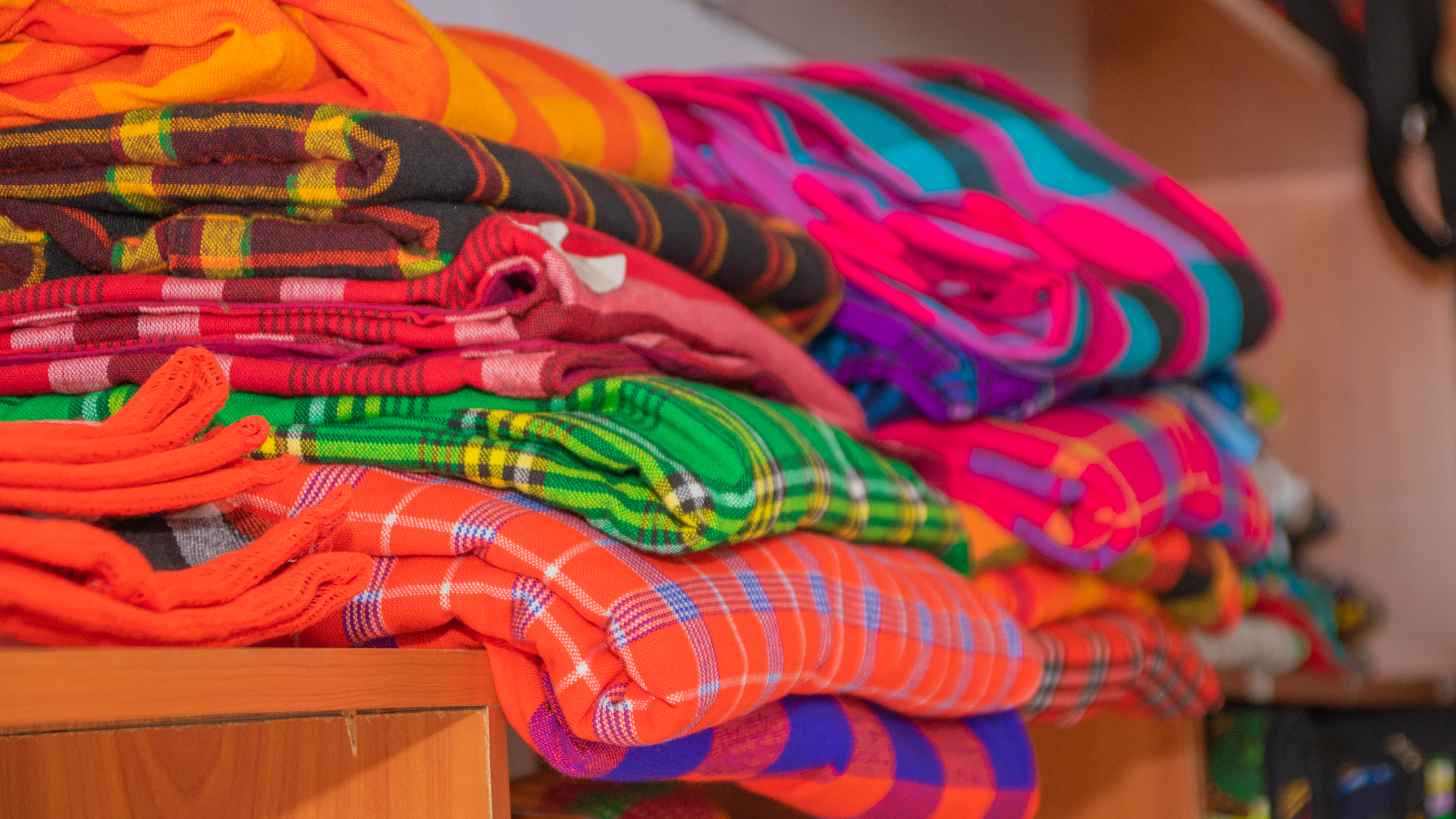 Close-up of stacked, vibrant plaid Maasai shuka blankets